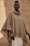Black woman wearing a luxurious camel knit poncho draped over her shoulders