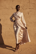 Black woman wearing an elegant flowing midi dress in blush fabric