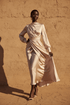 Black woman wearing an elegant flowing midi dress in blush fabric The Soft Life Dress